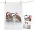 Weißes MALUU Baumwolle Geschirrtuch mit einem winterlichen Aquarell-Motiv von einem Hasen und einem kleinen Igel in festlicher Stimmung.